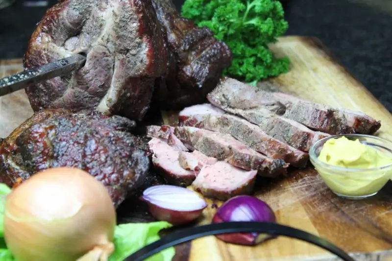 Saftiger Mutzbraten, frisch aufgeschnitten, mit Zwiebeln, Senf und Petersilie. Ein tolles Rezept für den Grill.